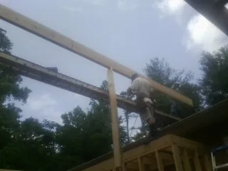 Carpenter setting a ridge beam over a new addition frame — Ice Dam Removal by Roofing Brothers in New Britain