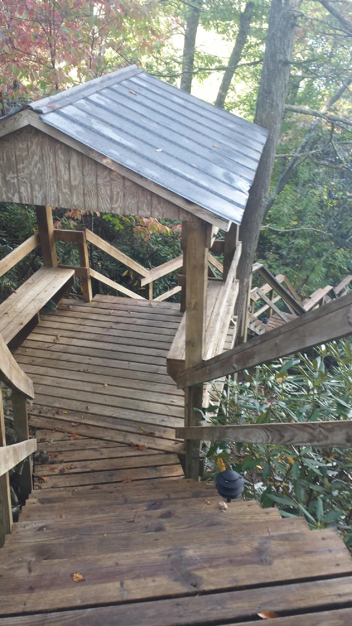 Metal roofed shelter over wooden steps on a wooded walkway — Skylight Repair & Installation work by our crew in New Britain