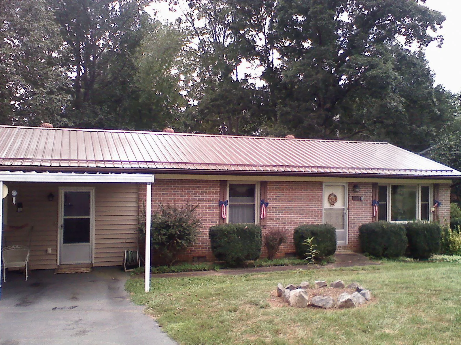 Bronze metal roof and carport on a brick ranch home — Roof Repair work by our crew in New Britain